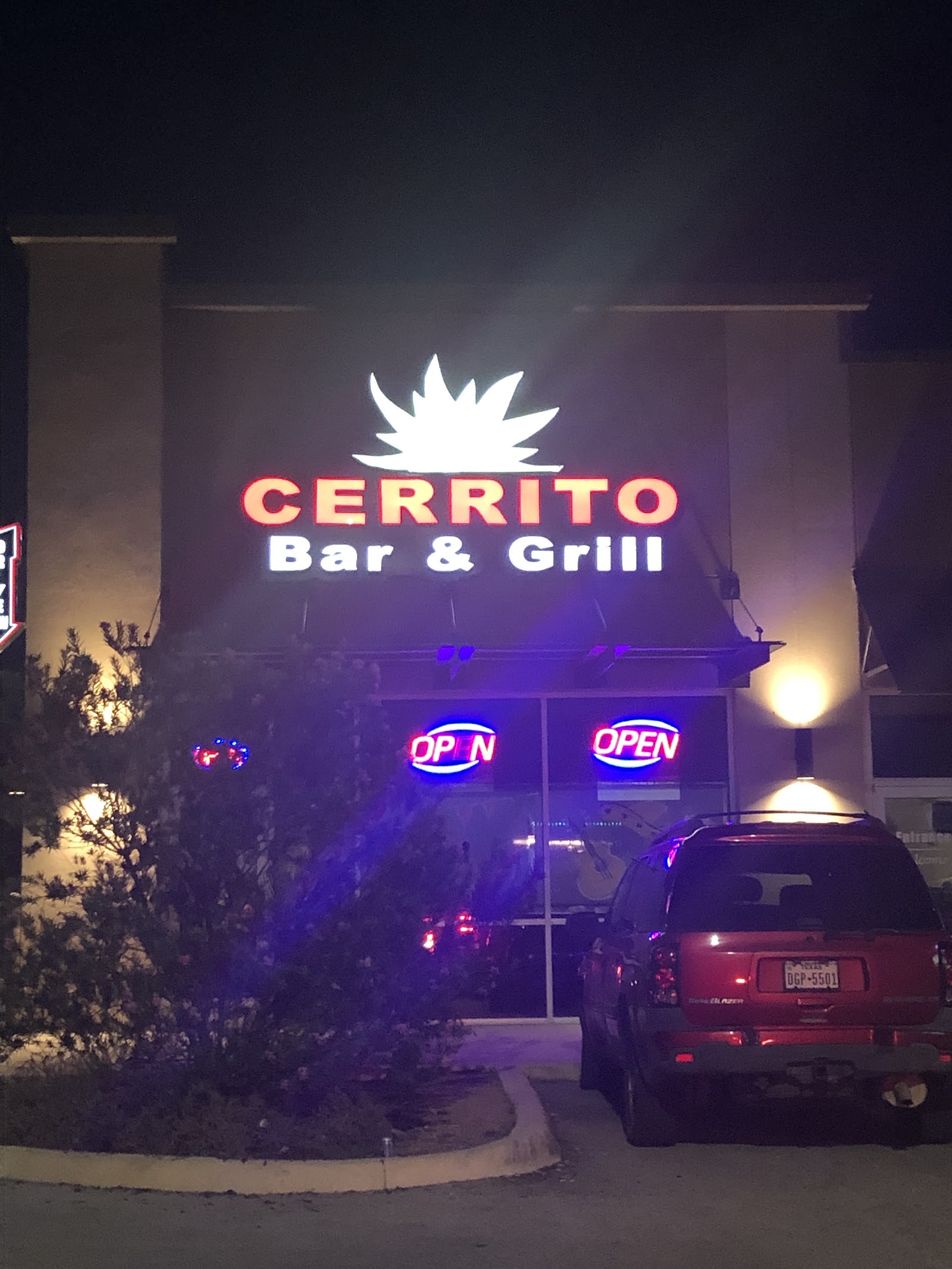 Cerrito Bar & Grill storefront lit up at night with neon OPEN signs